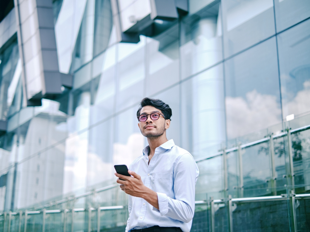 man-outside-office-with-smartphone
