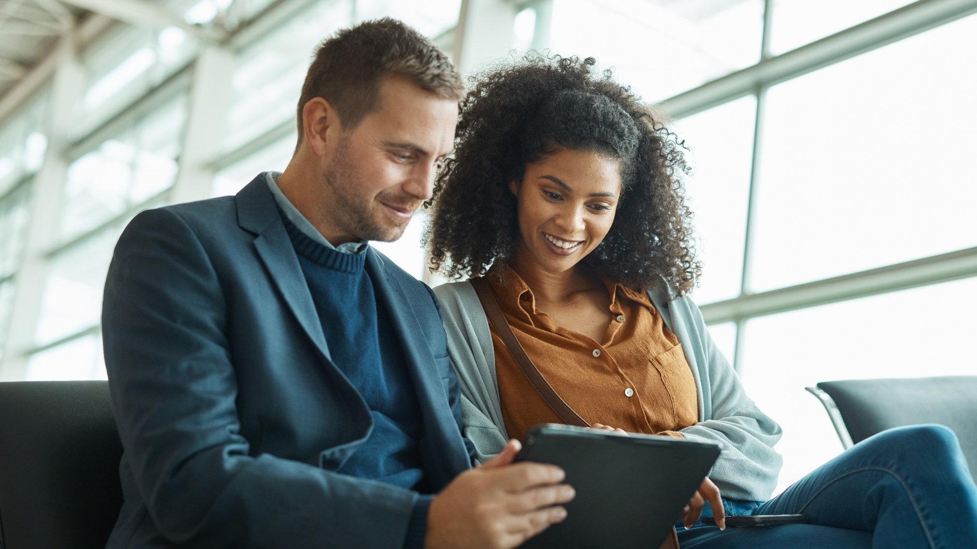 man-woman-using-tablet-airport